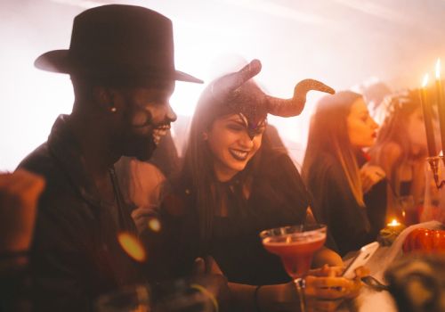 People in costumes enjoying drinks at a party, with a festive and lively atmosphere.
